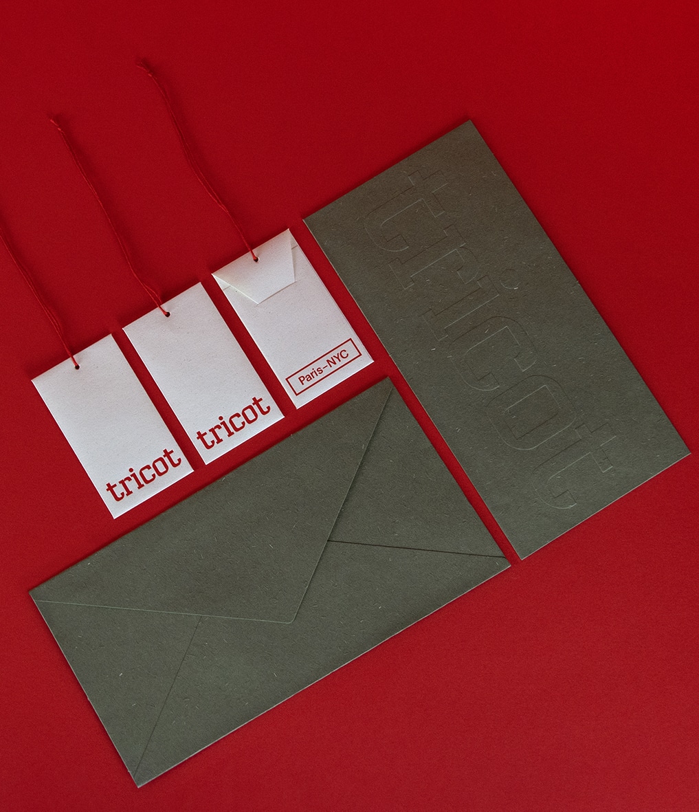 Gamme papeterie Tricot avec enveloppe et hangtag en papier blanc et avec fil rouge.