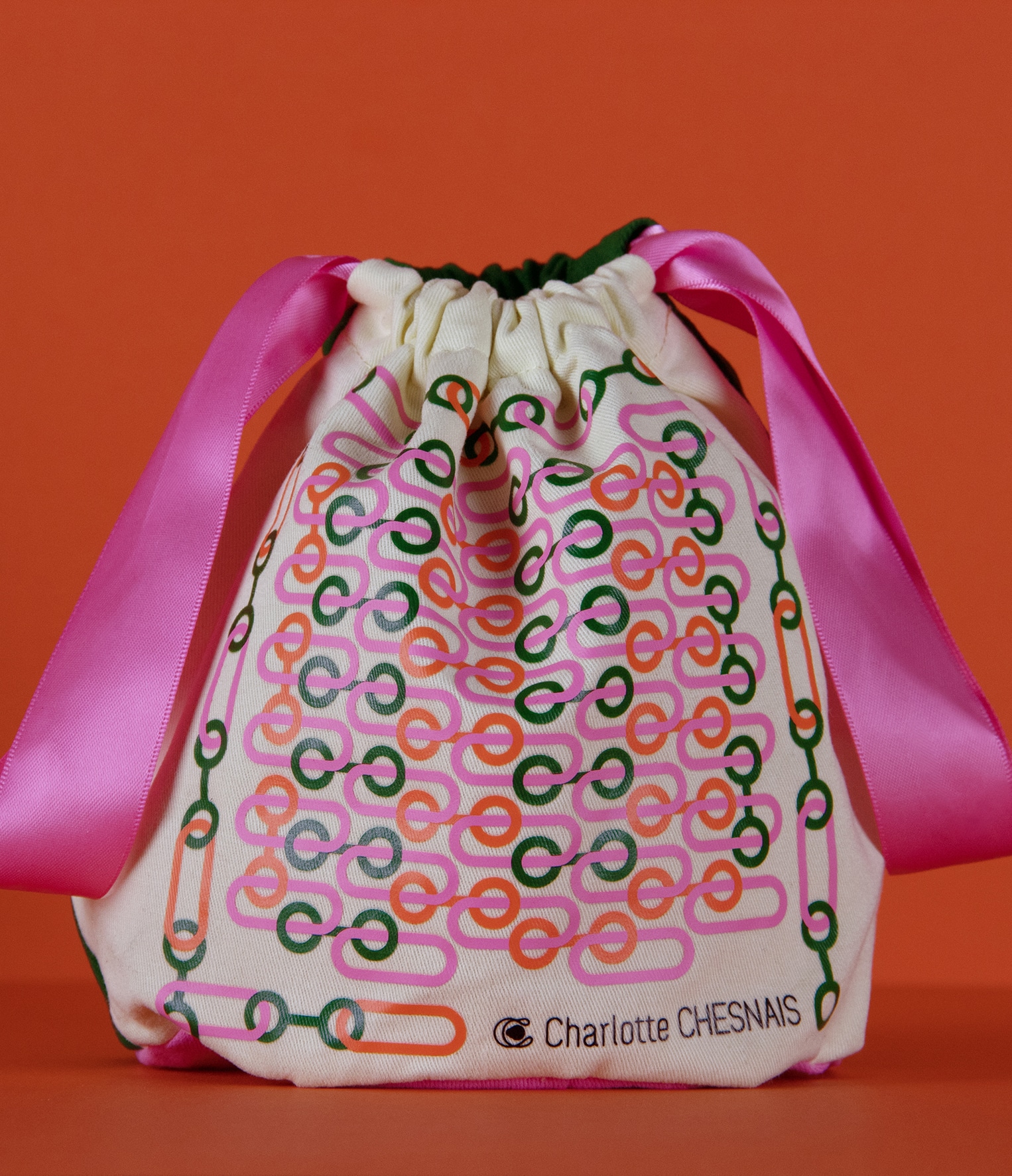 Pochon Charlotte Chesnais avec sérigraphie couleurs vives et ruban rose pour la collection noël 2021.