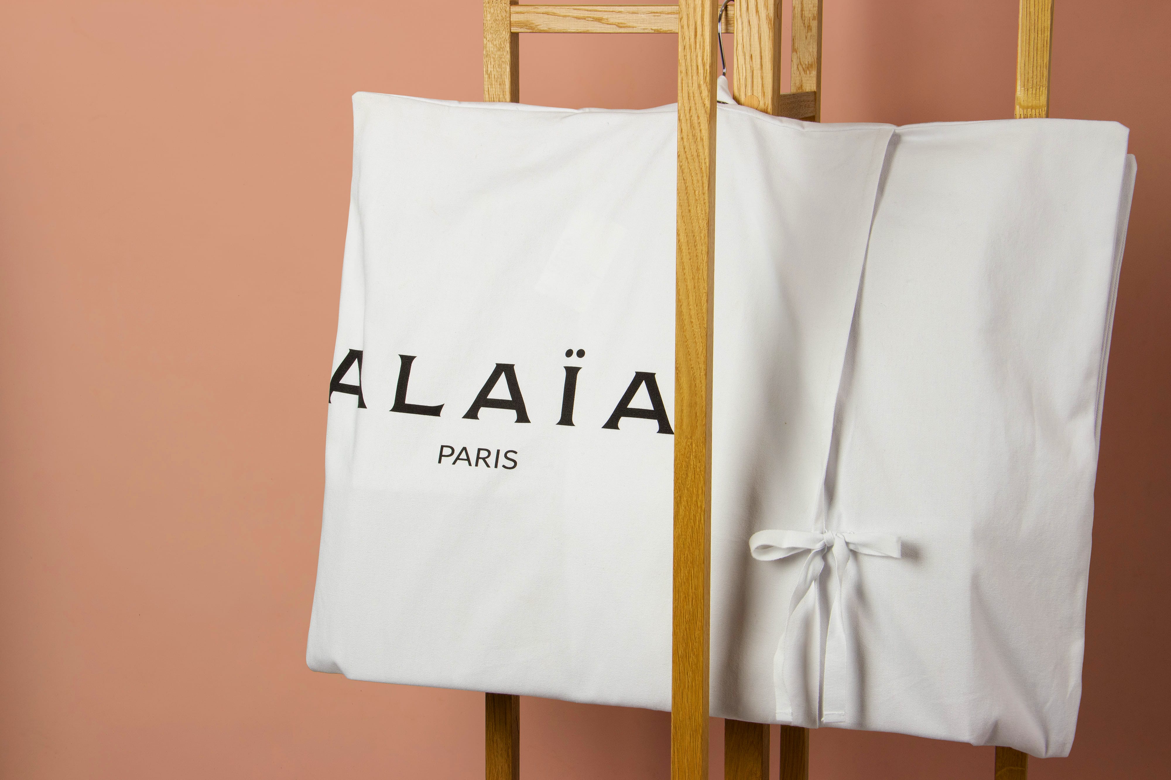 Housse vêtement en coton blanc Alaïa pour créations haute couture avec noeuds de fermeture et sérigraphie noire